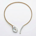 Gold necklace with a large pearl pendant on a white background