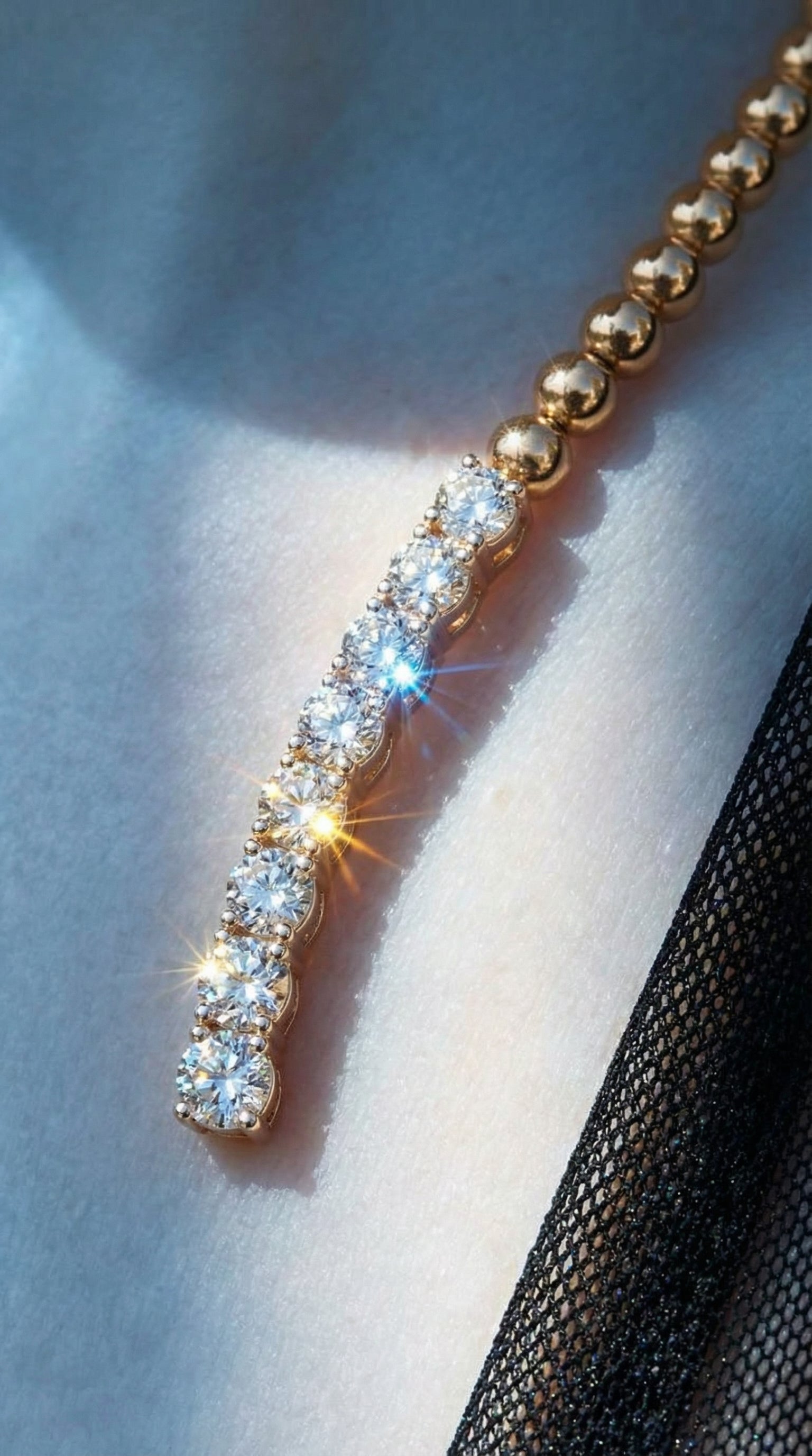 Gold necklace with a diamond pendant on a light background