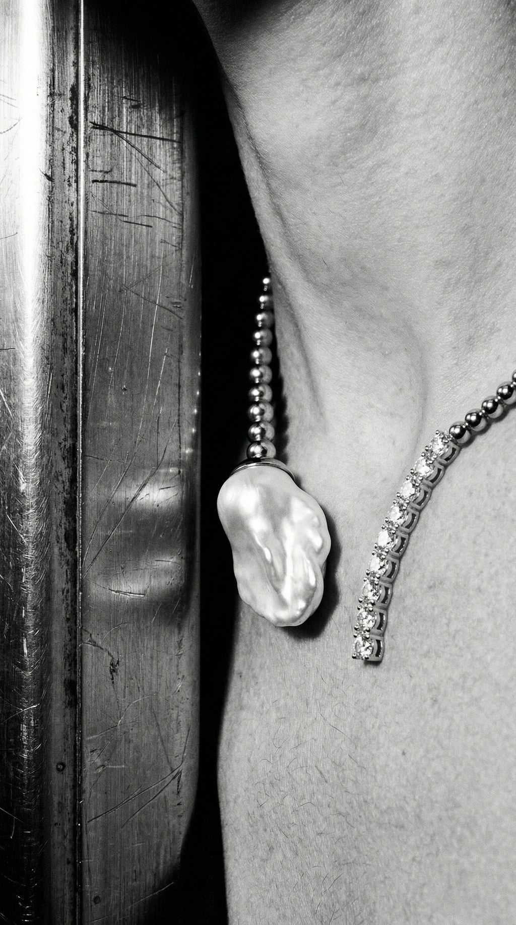 Close-up of a pearl and diamond necklace on a neck.