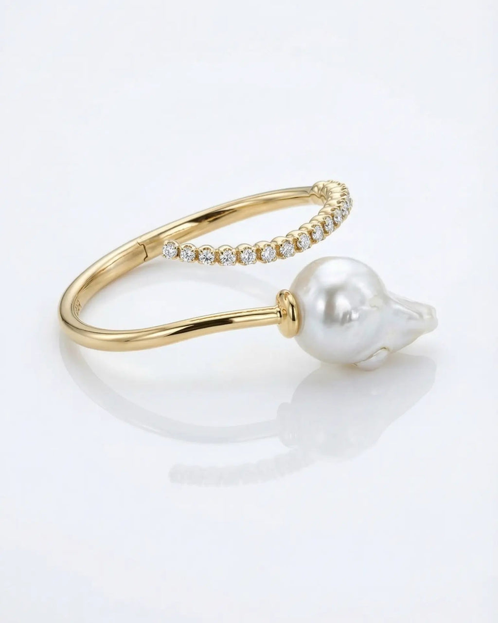 Gold and diamond bracelet cuff with a pearl on a white background